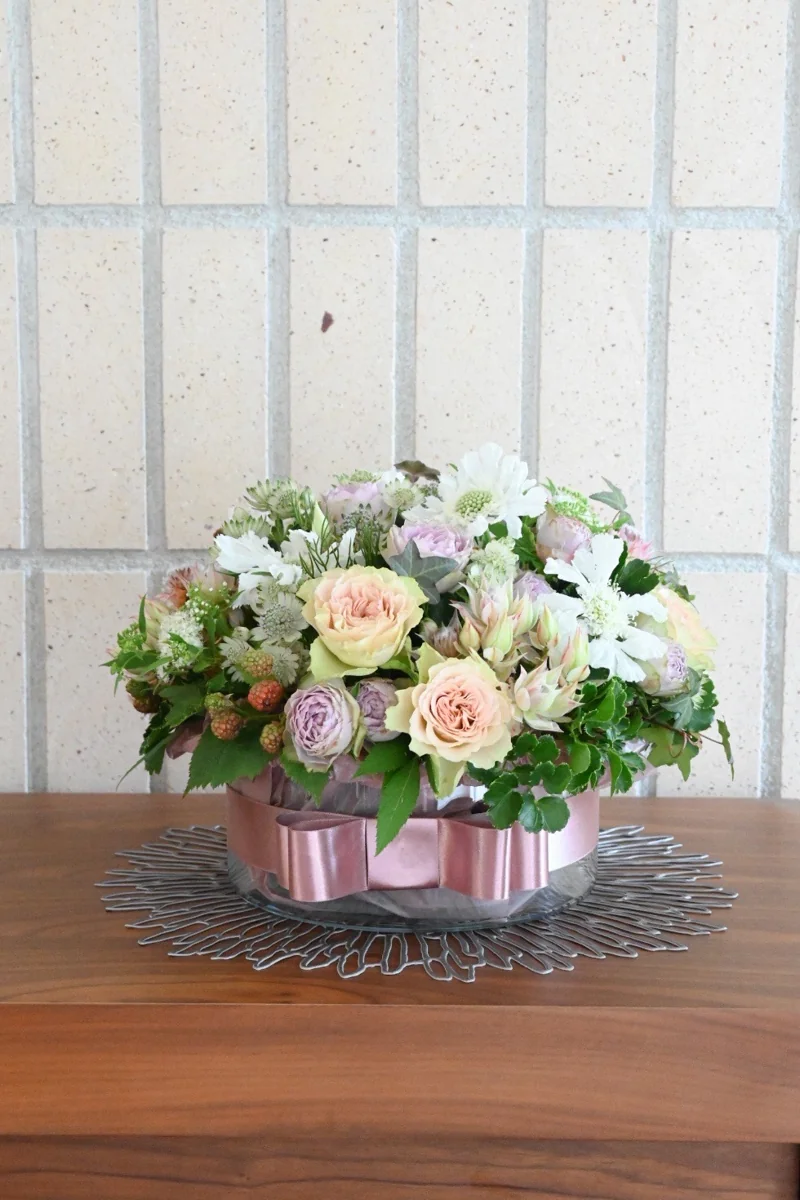 淡いピンクや白の花をたっぷり飾った作品